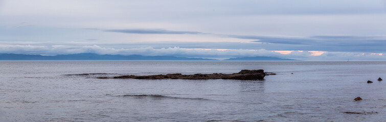 Beautiful Panoramic View of a rocky beach on the Juan de Fuca Trail during a summer sunset. Taken at Chin Beach, near Port Renfrew, Vancouver Island, BC, Canada.