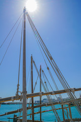 Ropes and spars of traditional rigging of dhow moored along Doha Old Town waterfront.