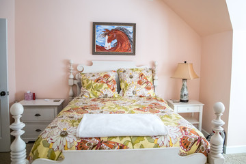 floral bedspread comforter bedding in a teenage girls pink bedroom with a horse