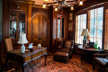 Dark stained wood stained home office with warm rust desert color with wood furniture, desk, lamp...