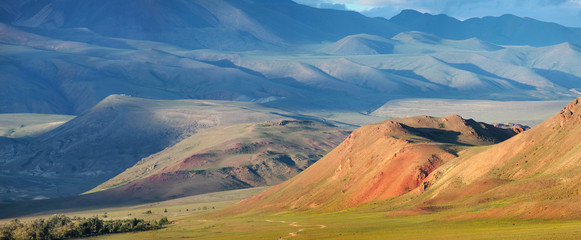 Fototapeta na wymiar Panoramic view of mountains in the south of Altay, Mongolian landscapes. Dry mountain slopes and evening light.