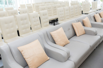Sofa and White chairs arranged in seminar room