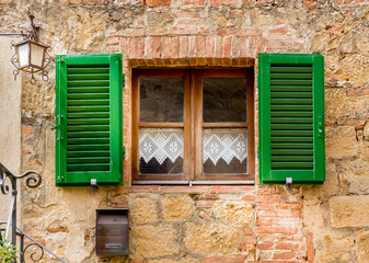 Fototapeta na wymiar Traditional Tuscan home with green shutters