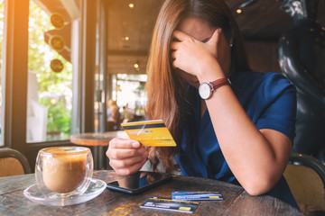 Closeup image of an Asian woman get stressed and broke while holding credit card