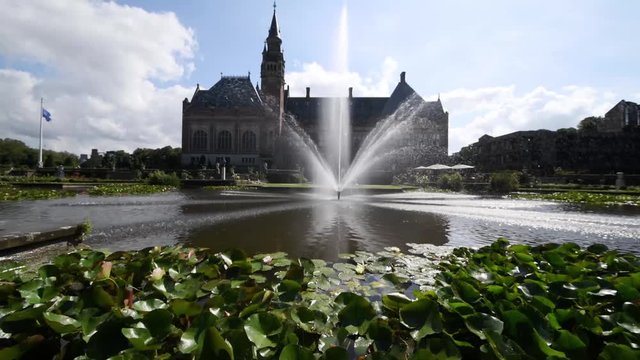 Garden of the Peace Palace, the seat of the International Court of Justice under a sunny and cloudy summer day.