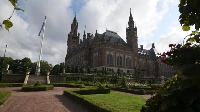 Garden of the Peace Palace, the seat of the International Court of Justice under a sunny and cloudy summer day.