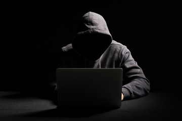 Hacker working on laptop in the dark - obrazy, fototapety, plakaty