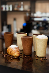 Glasses for coffee with a croissant on the table in the interiors of the bar.