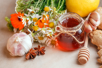 Harvesting herbs, flower garlic, lemon, ginger root, honey in jar - concept of seasonal winter autumn fall days, beverage for cold flu treament, alternative meidicne