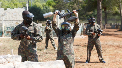 Fototapeta premium Woman playing paintball outdoors