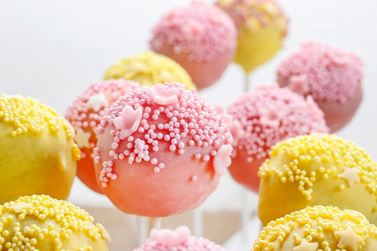 Pink and yellow cake pops decorated with sprinkles