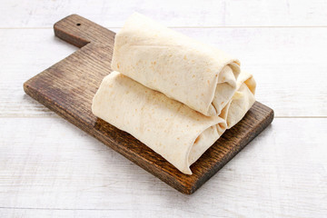 Fototapeta na wymiar A burrito - mexican dish that consists of a flour tortilla with various ingredients.