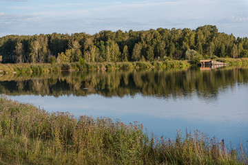 Fototapeta na wymiar small lake in the forest. lake in Russia. Lake Shore. to fish on the lake. beautiful landscape. admire the lake.