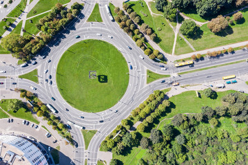 cars in a roundabout junction in urban residential area. birds eye view