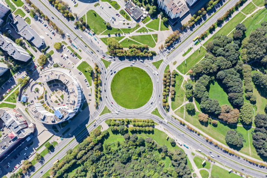 city street roundabout with little traffic of cars in summer time. aerial top view 