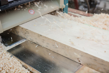 planing boards on a thicknesser. wood shavings. machine for planing wood. carpentry work. joiner's...