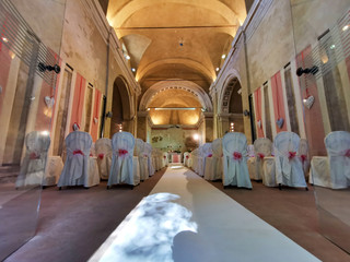 interno di chiesa addobbata con fiori e sedie bianche
