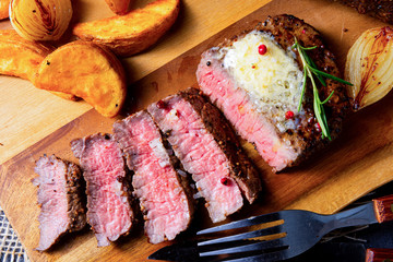 rustic medium butter beef steak with herbs and potato wedges