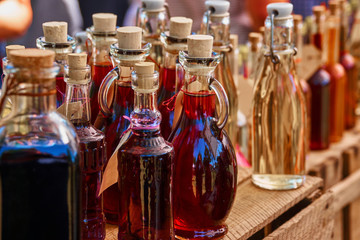 Obraz na płótnie Canvas Bottles of homemade liqueur and schnapps on a wooden shelf