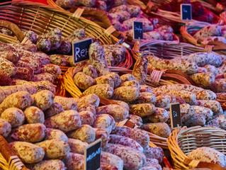 French sausages in braided baskets on the sales stand at a weekly market
