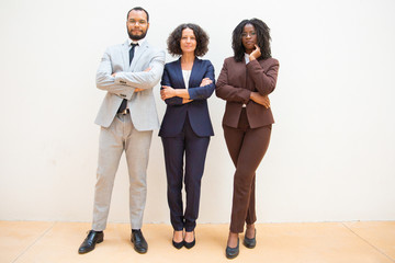 Obraz premium Confident business people posing with arms folded. Business man and women standing over white background and looking at camera. Team portrait concept