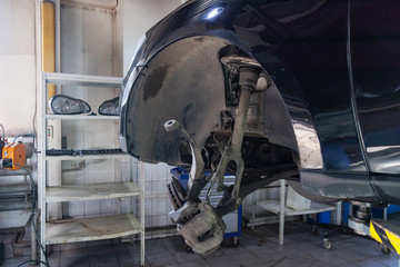 A close-up on the brake system of a car with pads, discs, a caliper on a lift in a vehicle repair workshop. Auto service industry.