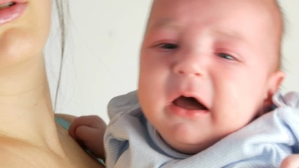 A two month old newborn baby cries loudly. Childs face close up view
