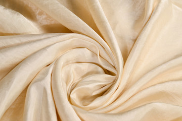 Soft smooth beige silk fabric background. Fabric texture.