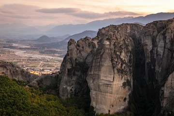 NAtural pillars in central Greece in dramaticsunset conditions with no people and Kalabaka town in the background. Destination - meteora moansteries.