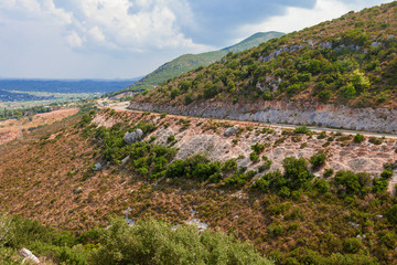 Empty mountain road on a background of gloomy sky