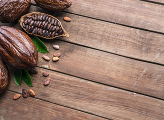 Cocoa pod and cocoa beans on the wooden table. Top view.