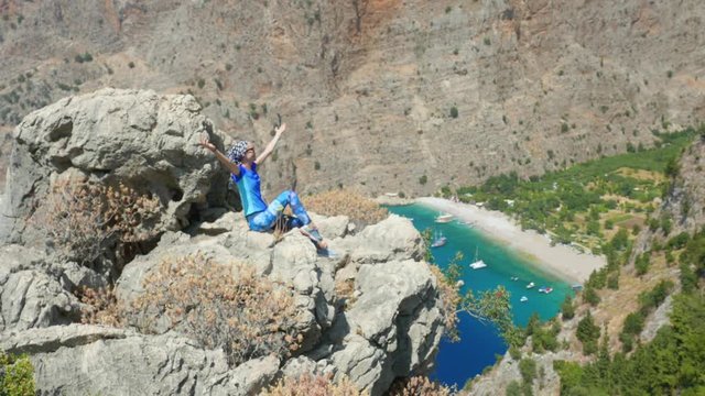 Young woman enjoying freedom and taking sun bath with beatiful viewn of Butterfly Valley on background in Turkey