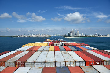 Large, fully loaded cargo container ship arriving to the port of Miami, Florida. 