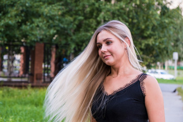 Naklejka premium Portrait of a young woman with long shiny blond hair. Hair care concept.