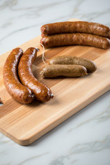 Regionale norddeutsche Grünkohl Kohlwurst Variation aus Bremer, Oldenburger und Ammerländer Pinkel auf  Holzbrett auf Marmor Tisch