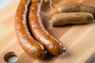 Regionale norddeutsche Grünkohl Kohlwurst Variation aus Bremer, Oldenburger und Ammerländer Pinkel auf  Holzbrett auf Marmor Tisch