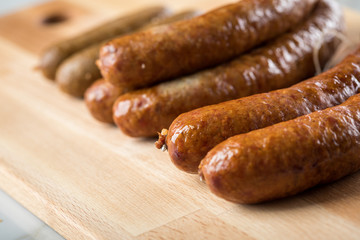 Regionale norddeutsche Grünkohl Kohlwurst Variation aus Bremer, Oldenburger und Ammerländer Pinkel auf  Holzbrett auf Marmor Tisch