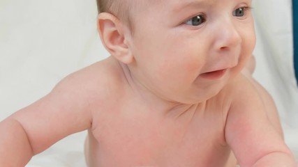 Portrait of beautiful funny little newborn baby of two months lying on a white bed
