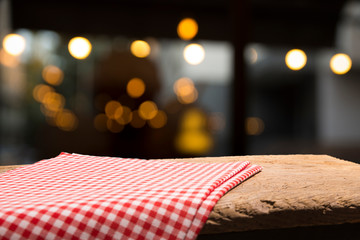 Empty wood table top on blur light gold bokeh of cafe restaurant in dark background
