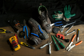 Low key light photography of the tools of a worker electrician. on a wooden vintage table after...