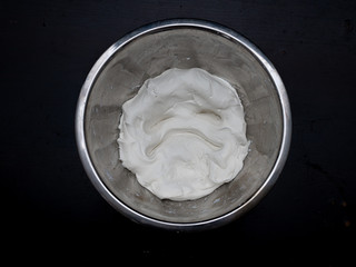 A terrible ugly grimace of dough in a metal dish on a black background.