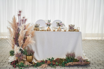 Wedding decoration in boho style. Light colors, in the tent.Wedding table decorated with pampas...