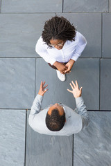 Business colleagues accidently meeting near office. Top view of business man and woman standing...