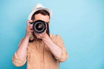 Obraz premium Portrait of concentrated person making photo looking wearing brown shirt isolated over blue background