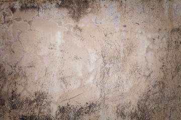 Obraz premium Old beige wall covered with uneven plaster. Texture of vintage shabby sand brick surface, closeup.