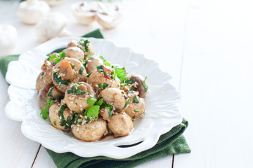 Marinated champignons with spices, herbs and sesame on a white plate, horizontal, copy space