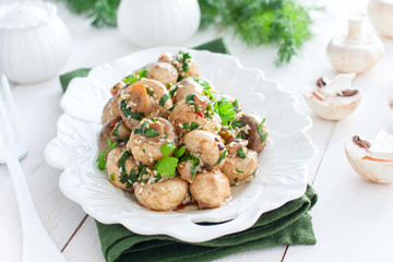 Marinated champignons with spices, herbs and sesame on a white plate, horizontal