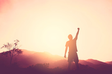 Copy space of man rise hand up on top of mountain and sunset sky abstract background.