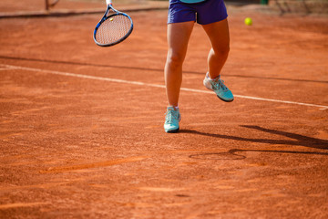 Fototapeta na wymiar Unrecognizable woman playing tennis on clay court