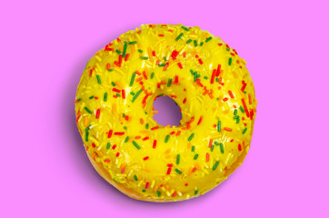 Sweet green donut with multicolored sprinkles on a pink background flat lay stock photo